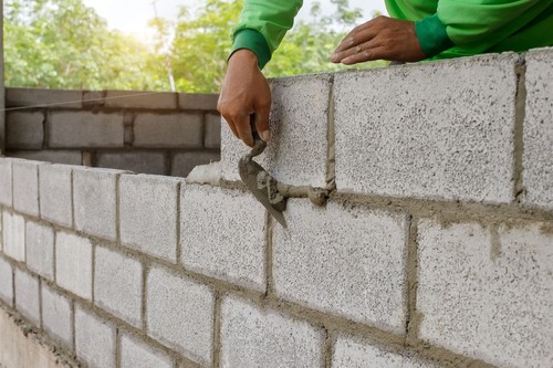 Masonry Worker Making Concrete Wall with Cement Block And Plaster